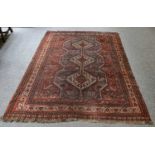 A Kashgai rug, the mid indigo field with three stepped medallions surrounded by stylised birds,