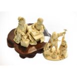 A Japanese Meiji period carved ivory okimono, formed as a seated mother and child, the mother sewing