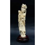 A 19th century Chinese carved ivory figure of Guanwin holding a peoni dressed in flowing robes and