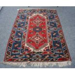 A Dosemealti rug, the raspberry field with three hooked medallions enclosed by sky blue borders,