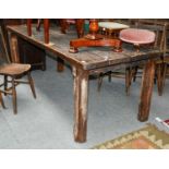 A provincial plank top table (distressed, fitted with a vice and has been used as a workbench),