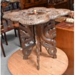 A Burmese carved hardwood table, decorated with dragons, 70cm by 70cm by 70cm