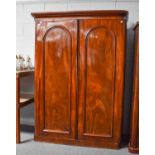 A Victorian mahogany double wardrobe with arched panel doors 152cm by 62cm by 210cm, together with a