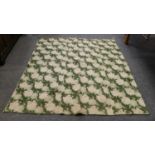An early 20th century wholecloth reversible quilt with white flower heads on a green ground, and