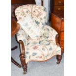 A Victorian buttoned back armchair with carved mahogany framed floral upholstery