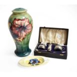 A Moorcroft baluster table lamp base in the hibiscus pattern, and a Moorcroft ashtray in the pansies