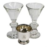 A pair of David Wallace knop stemmed glasses together with a silver christening mug, engraved M,