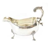 An Edward VII Silver Sauceboat, by Synyer and Beddoes, Birmingham, 1903, oval and on three feet,