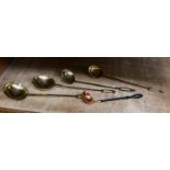 A collection of 19th century brass ladels and a copper punch ladel inlaid with a Britannia coin