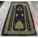 A large black wool eastern wall hanging embroidered in gilt and coloured silk threads in