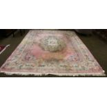 A Chinese carpet of Savonnerie design, the pink field of floral medallion enclosed by similar