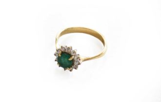 An emerald and diamond cluster ring, stamped '18CT', finger size K1/2The ring is in fair condition