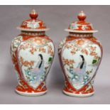 A pair of Japanese baluster-shaped jars and covers, Meiji period, red ground and with shaped