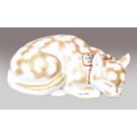 A Japanese Kutani model of a sleeping cat, Meiji period, its furr picked out in gilt and with a