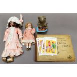Two German bisque head dolls, a group of novelty seaside postcards, a Japanese clockwork toy, a