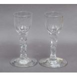 A pair of wine glasses, circa 1770, each engraved to the bowl with a bird in flight and a flower