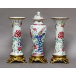 A garniture of three Chinese famille rose vases, Qianlong, painted with peonies and rocks, the