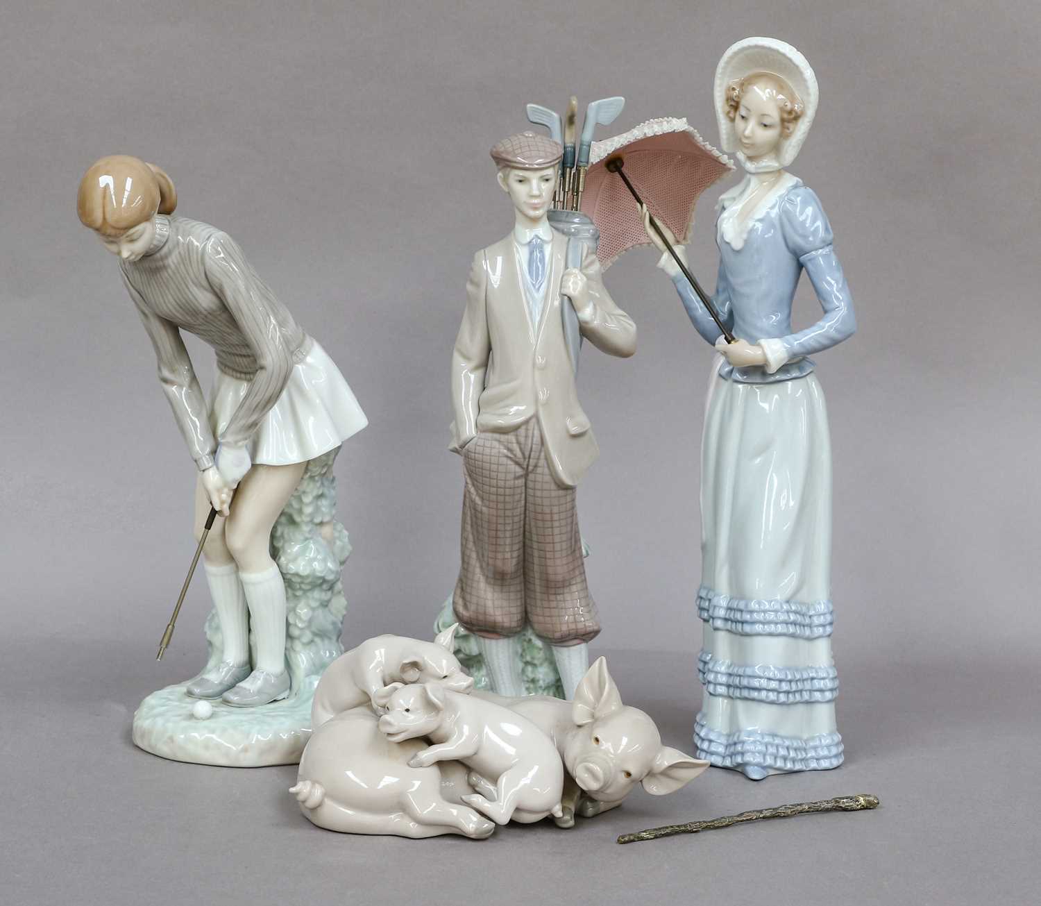 Three Lladro figures, together with a Lladro group of pigs