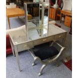 A silvered and mirrored dressing table, 122cm by 60cm by 75cm, together with a matching triptych