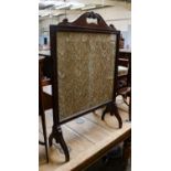 An early 20th century carved mahogany fire screen with crewelwork panel, 69cm by 102.5cm, together