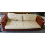 A pair of three-seater sofas, modern, covered in red leather with cream cushions, on metal tubular