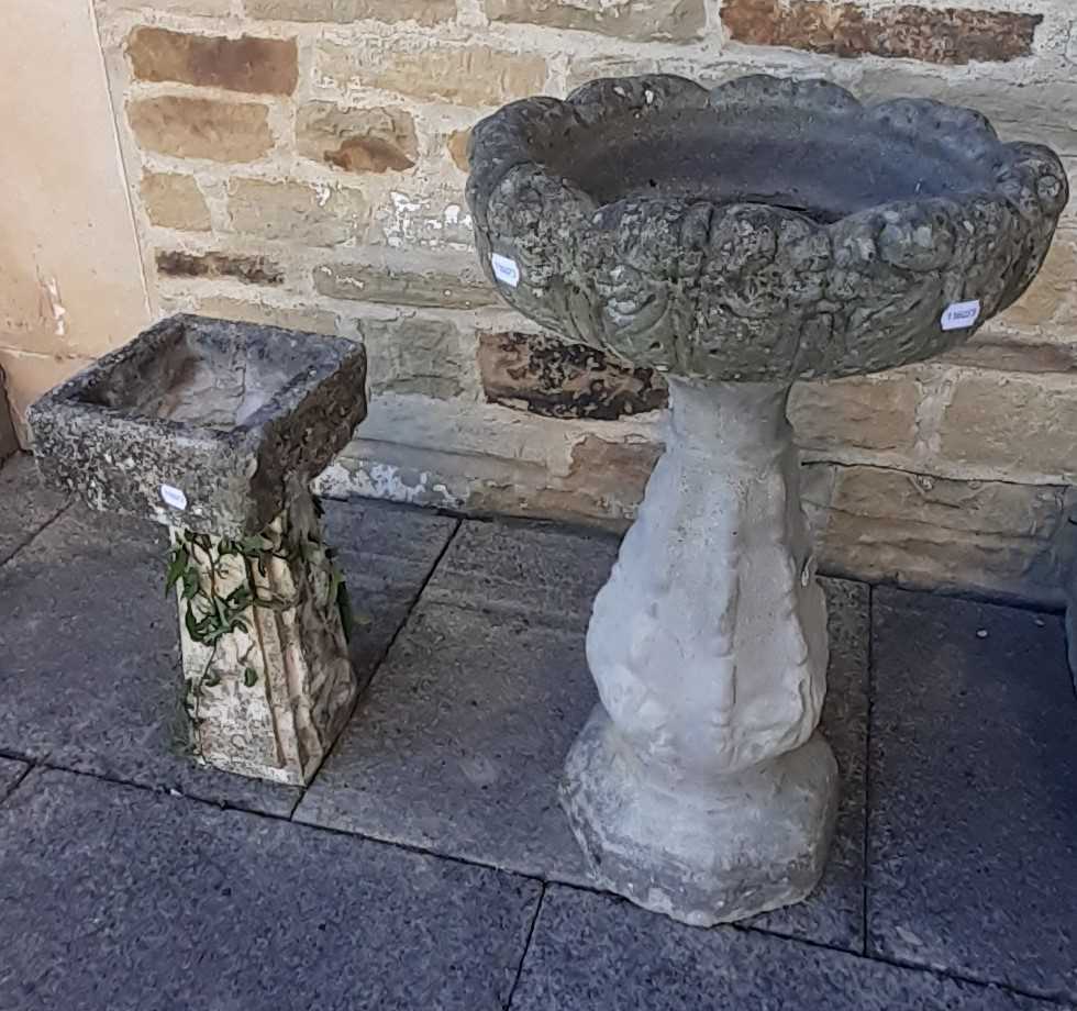 A weathered composition stone bird bath, 47cm by 76cm, together with a smaller example, 23cm