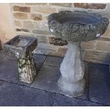 A weathered composition stone bird bath, 47cm by 76cm, together with a smaller example, 23cm