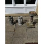 A weathered stone bird bath, together with two composition Easter Island heads (2)