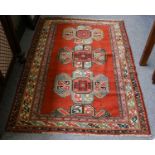 Karabagh rug, the terracotta field with three medallions enclosed by triple borders, 173 by 112cm