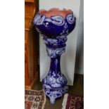 An Art Noveau pottery Jardiniere and stand, moulded with stylised plants and ground in cobalt