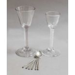 A wine glass with large funnel shaped bowl, plain stem and with folded foot; together with a similar