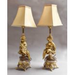 A pair of gilt metal and marble electric table lamps as putti34cm to the fitting. The meltal is