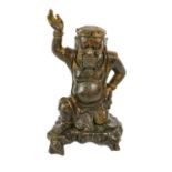 A Chinese copper alloy figure of an immortal, Qing Dynasty, probably 18th century, the kneeling
