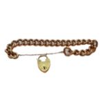 A curb link bracelet, with a 9 carat gold heart-shaped padlock clasp, length 19.5cmThe bracelet is