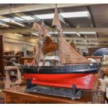 A large painted model of a twin masted fishing trawler on stand, 154cm long, together with a pond