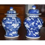 A pair of Chinese baluster form blue and white porcelain vases and covers, Kangxi reign marks but