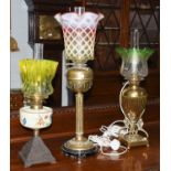 Three oil lamps, one with a large cranberry vaseline shadeThe cranberry and vaseline shade, free