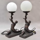 A pair of bronzed composite Art Deco style figural table lamps (with associated ill matching shades)