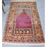 An Anatolian prayer rug, the stepped abrashed field beneath the Mihrab enclosed by floral borders,