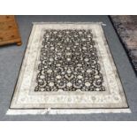 A modern silk rug, probably Kashmir, the charcoal field of meandering vines enclosed by ivory