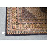 A machine made carpet, the Herati field centred by a stepped medallion, framed by spandrels and