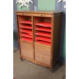 A 1920s Oak Tambour Fronted Stationary Cabinet, with moulded corners and raised on scroll