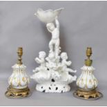 A Modern White Glazed Italian Figural Centrepiece, moulded with musical putti, together with a