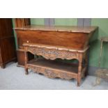 A Carved Oak Dough Bin on Stand, 18th century, with shaped top, on a conforming base with carved