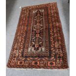 A Baluch Rug, the field with a row of diamond medallions enclosed by stylised vine borders, 204cm by