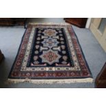 A North-West Persian Rug, the indigo field with three stepped medallions enclosed by polychrome
