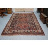 Khamseh Carpet, the indigo field with three hooked diamond medallions surrounded by tribal motifs,