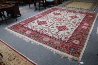 An Indian Carpet, the ivory stepped lattice field enclosed by crimson borders, 370cm by 290cm