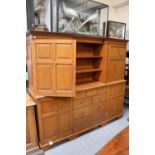 An Oak Dresser, the inverted breakfront top with central recessed shelves flanked by panelled