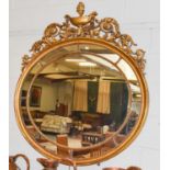 A Gilt Framed Sectional Oval Mirror, 20th century, with urn and scrolling leaf surmount, 113cm by